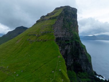 Danimarka 'nın Faroe Adaları' ndaki Kallur deniz fenerinin yanındaki tepeler..