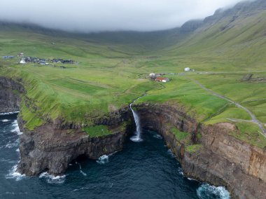 Faroe Adaları 'ndaki Gasadalur Köyü ve Mulafossur Şelalesi' nin hava manzarası.