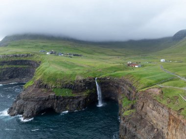 Faroe Adaları 'ndaki Gasadalur Köyü ve Mulafossur Şelalesi' nin hava manzarası.