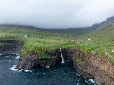 Faroe Adaları 'ndaki Gasadalur Köyü ve Mulafossur Şelalesi' nin hava manzarası.