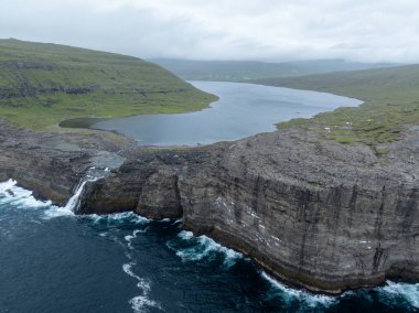 Bosdalafossur waterfall, that falls directly into the ocean. Sorvagsvatn Lake in Vagar, Faroe Islands, Denmark, Europe. clipart