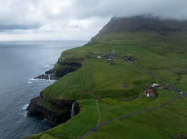 Faroe Adaları 'ndaki Gasadalur Köyü ve Mulafossur Şelalesi' nin hava manzarası.