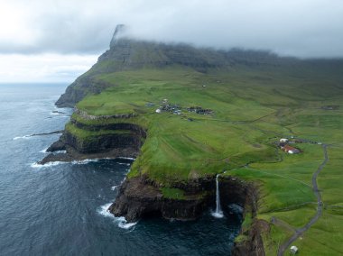 Aerial view of Gasadalur Village and Mulafossur Waterfall in the Faroe Islands. clipart