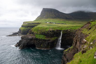 Faroe Adaları 'ndaki Gasadalur Köyü ve Mulafossur Şelalesi' nin hava manzarası.