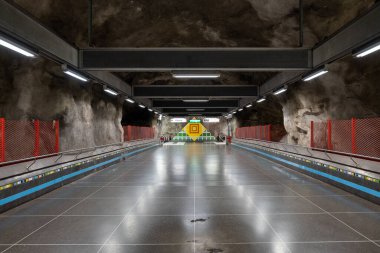 İsveç, Stockholm, 4 Ağustos 2024: Yeraltı metro tüneli istasyonu Vastra Skogen (mavi hat, merkez istasyon) renkli desenli mağaralar duvarlar ve tavan.