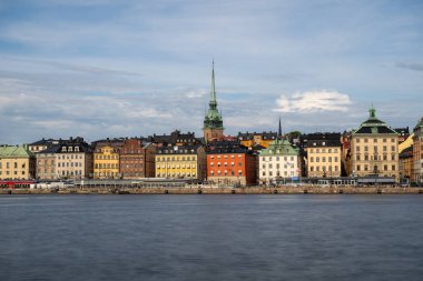 Serene Stockholm skyline at sunset, with historic architecture, calm waterfront, and boats, viewed from Skeppsholmen. Tranquil Nordic charm. clipart