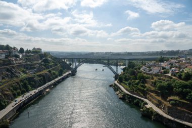 Dona Maria Pia Köprüsü ve Douro Nehri boyunca uzanan Sao Joao Köprüsü, sakin sularda manzaralı yamaçlar ve botlarla