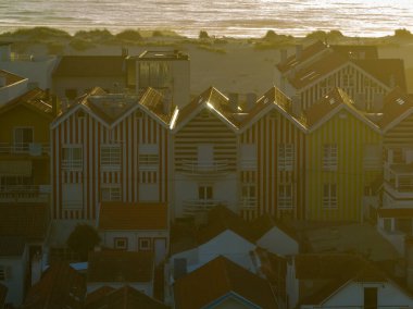 Colorful striped houses called Palheiros with red, blue and green stripes. Costa Nova do Prado is a beach village resort on Atlantic coast near Aveiro. clipart