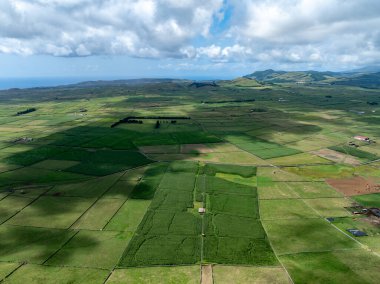 Miradouro da Serra do Cume 'un geniş panoramik manzarası Azores' deki Terceira Adası 'ndaki geniş düz alana çiftçi tarlalarının yamalı örtüsüyle bakıyor.