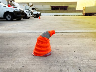 The damaged safety cone put on the ground of transport yard with yellow light