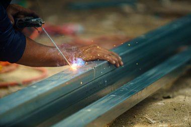 Ağır sanayide güvenliği olmayan tamirci kaynakçısını kapatın. Tehlikeli ve güvensiz bir kavram..