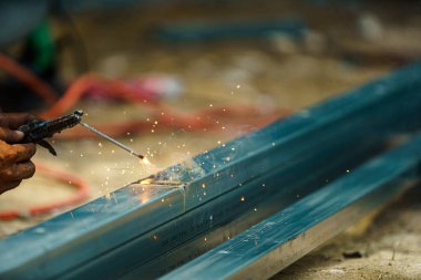 Ağır sanayide güvenliği olmayan tamirci kaynakçısını kapatın. Tehlikeli ve güvensiz bir kavram..