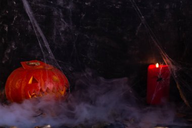 Duman içindeki Cadılar Bayramı süslemeleri, balkabağı ve mumlar, örümcekler, balkabağından gelen balkabağı feneri, esrarengiz bir şekilde. Yüksek kalite fotoğraf