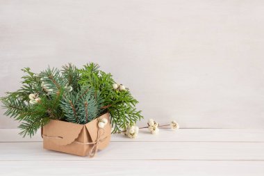 Beyaz ve yeşil renkte Noel süslemesi, beyaz masada Noel çamı buketi, fotokopi alanı. Yüksek kalite fotoğraf