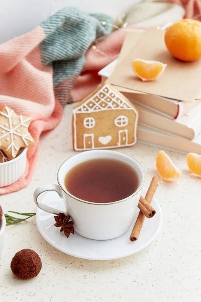 Aesthetic holidays mood with coffee, tangerines, homemade ginger cookies in shape of cute home near books. Aesthetic female Christmas background.