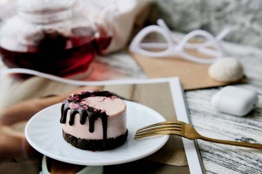 Pembe glüten ve şekersiz kaju fıstıklı ahudududulu kek ve dergi ve çaydanlık. Sağlıklı vejetaryen tatlı.