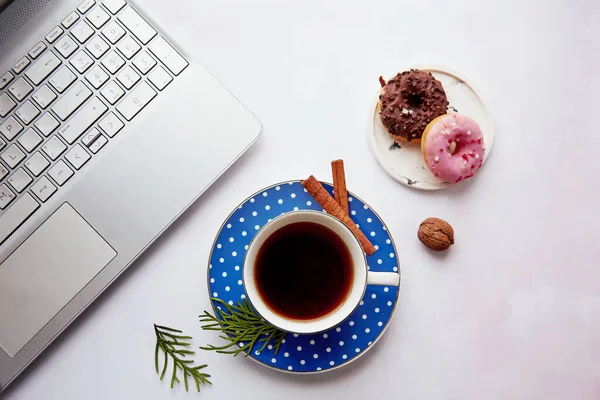 Aesthetics breakfast at home - with cup of coffee, doughnuts and laptop. Cozy home