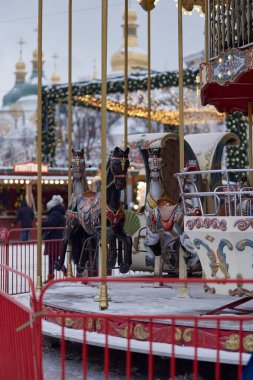 Noel Atlıkarınca, tapınağın kubbesi ve karlı bir akşamın akşamında ışıklar.