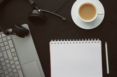 Kaliteli düz ofis, defter, kahve, dizüstü bilgisayar ve kulaklık. Yeni yıl kararları ve hedefleri kavramı