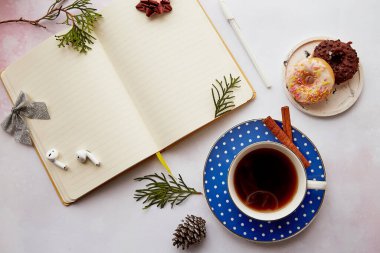 Estetik kahve fincanı, donut, kulaklık ve Noel süslemeleri olan sezonluk boş bir not defteri. Yeni yıl çözümü, planlama, yeni başlangıç ve hedef listesi kavramı.
