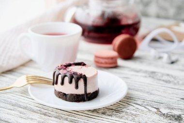 Kadın kahvaltısı - pembe ahudududulu kek ve bir fincan çay yok. Sağlıklı vejetaryen tatlı. Mumlarla romantik yemek..