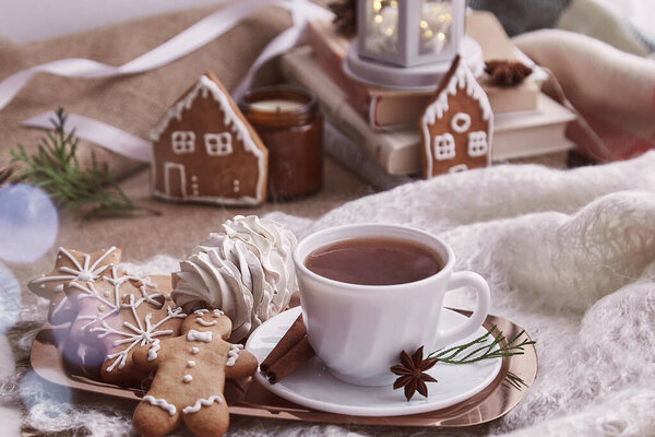 Уютное зимнее утро в снежный день. Рождественский теплый дом с книгами, имбирной кулинарией, зефиром, чашкой кофе на фоне.