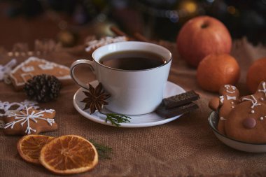 Estetik Noel kahvaltısı - bir fincan kahve, kurabiye, Noel ağacının yanında mandalina