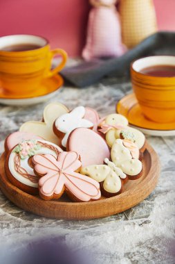 Festive Easter pastry cookies, cups of tea on the decorated table. Holiday tea time.