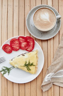 Vegan cheese pie with mushrooms, tomatoes and dill. Cup of coffee. Healthy breakfast. French food flat lay.