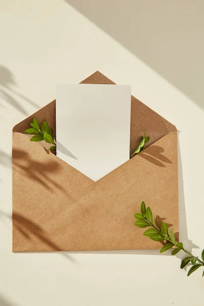 オープン封筒文房具カードモックアップ招待状 空白のグリーティングカードと影の下の緑の葉 最小限の組成 テキストの場所 — ストック写真