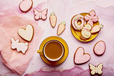 Estetik pastel Paskalya bayramı düzlüğü. Ev yapımı kurabiyeler ve sarı kahve fincanı. Mutlu Paskalya arkaplanları.