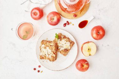 Elmalı turta ve cam çaydanlıkta sağlıklı böğürtlen çayı servis edilen masa manzarası. Meyve ve ballı elmalı turta tatlısı. Estetik gıda.