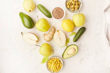 Kalp şeklindeki FODMAP, Paleo, Akdeniz diyet gıdaları sarı ve yeşil renklerde. Organik meyve, sebze, yeşillik, keten tohumu, zeytin.