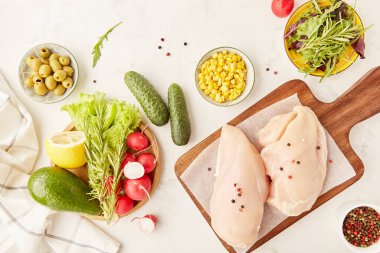 Ketogenik, Paleo, FODMAP, diyet konsepti. Meyveler, sebzeler, tavuk filetosu, zeytin ve yeşiller tahtada. Düz yerde yemek vardı..