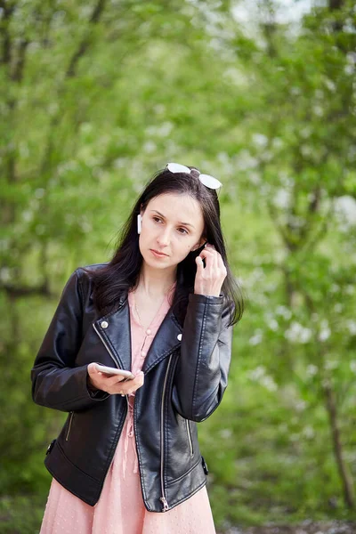 헤드폰으로 여자를 집중시키고 온라인 웹툰을 이용하는 전화로 이야기하는 비디오 온라인 — 스톡 사진