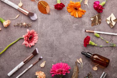 Estetik kadın kiti. Düşüren şişeler, makyaj fırçaları, güneş gözlükleri, aksesuarlar, kozmetik ürünleri ve Gerberler dairede fotokopi alanı olan düz uzanmış çiçekler..