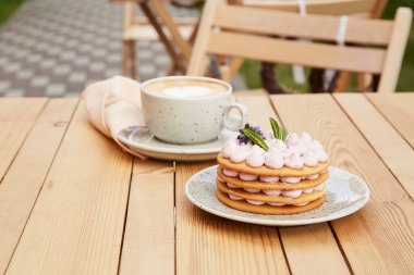 Estetik kafe terası. Bir fincan kahve ve şekersiz fransız kekinin olduğu kahve saati. Rahatlama ve rahatlama konsepti
