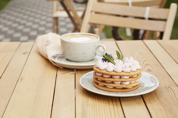 Estetik kafe terası. Bir fincan kahve ve şekersiz fransız kekinin olduğu kahve saati. Rahatlama ve rahatlama konsepti