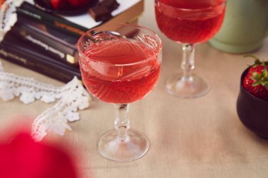 Samimi estetik masa düzenlemesi. Kırmızı ev yapımı cam, çilek şarabı, aşılama.