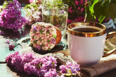 Çiçek baharı geçmişi. Estetik pembe kek, leylak çiçekli, kahve fincanı düz gölgelerin altında yatıyordu.