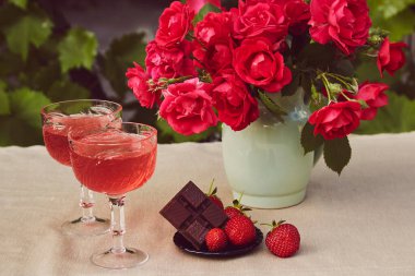 Yaz yemekleri hala hayat. Bir bardak kırmızı köpüklü çilek, çilek ve çikolata. Terasta tablo ayarları.