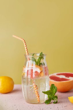 Turunçgil meyveli soğuk yaz arınma kokteyli. Estetik moda, alkolsüz içki. Dikey fotoğraf.