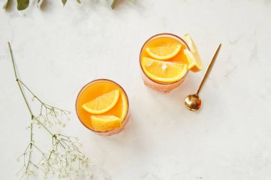 Turunçgil meyveli alkolsüz sağlıklı narenciye kokteyli. Arındırılmış vitaminli sağlıklı içecek. Az alkol, sıfır alkol konsepti. Moda gölgeler ve güneş ışığı