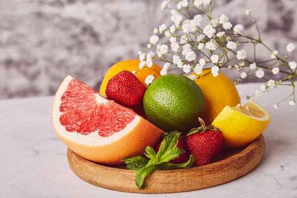Sağlıklı ahşap tabak ve taze narenciye. Organik, doğal vitamin arka planı. Boşluğu kopyala.