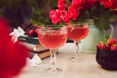 Estetik sehpası. Kırmızı ev yapımı, çilekli ve şaraplı bir çift. Gül buketi. Yaz arkaplanı.