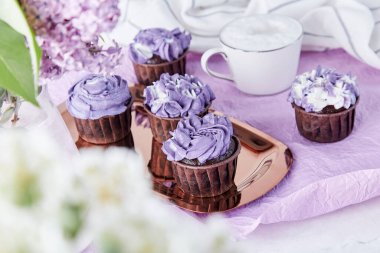 Çiçekli mor kekler, moda Hayalperestlik ve kahve fincanı. Kahve molası. Güzel yemek..