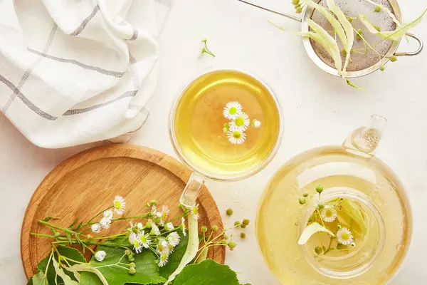 stock image Infuser, teapot, cup of healthy organic herbal linden, chamomile tea . Natural warm beverage, cozy table setting.