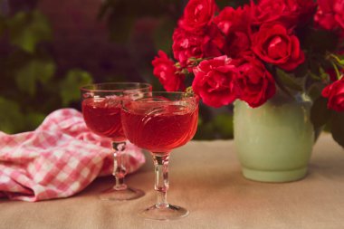 Estetik sehpası. Kırmızı ev yapımı, çilekli ve şaraplı bir çift. Gül buketi. Yaz arkaplanı.