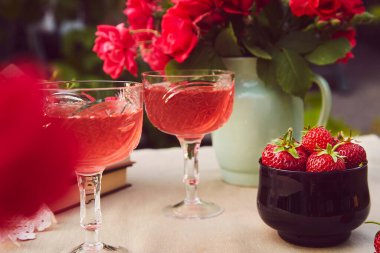 Samimi estetik masa düzenlemesi. Kırmızı ev yapımı, çilekli ve şaraplı bir çift. Güller buketi.