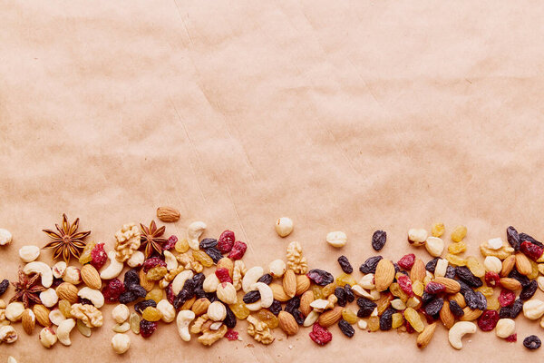 Assorted nuts mix in line with copy space. Healthy food and snacks. Walnuts, almonds, hazelnuts and cashews, raisins and cranberries